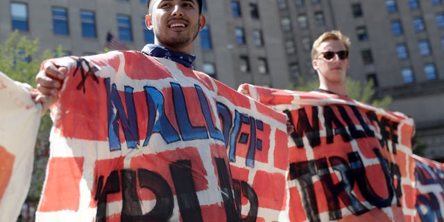 July 20, 2016: Immigrant rights activists hold up a fabric wall to protest Republican presidential candidate Donald Trump's border wall idea in Cleveland, during the third day of the Republican convention.