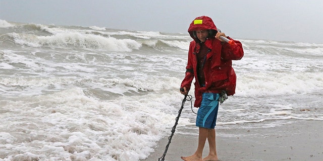 Local resident Mike Squillace looks for metal at Dania Beach, Fla., as Tropical Storm Gordon passes by South Florida with wind gusts and heavy rainfall on Monday.