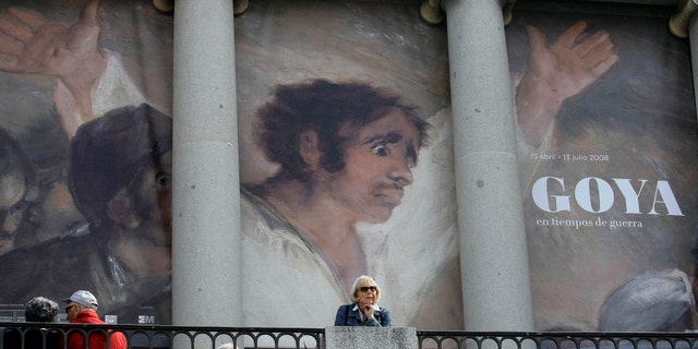 File photo - People sit in front of a banner announcing an exhibition by Spanish legendary artist Francisco Goya at Madrid's El Prado museum in Madrid April 15, 2008. (REUTERS/Andrea Comas)