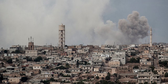 FILE 2013: smoke rises after a TNT bomb was thrown from a helicopter, hitting a rebel position during heavy fighting between troops loyal to president Bashar Assad and opposition fighters, in a neighbouring village to Kafr Nabuda, in the Idlib province.