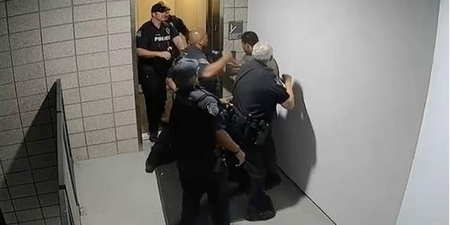 A screen grab from surveillance video shows Mesa Police Department officers repeatedly punching Robert Johnson.