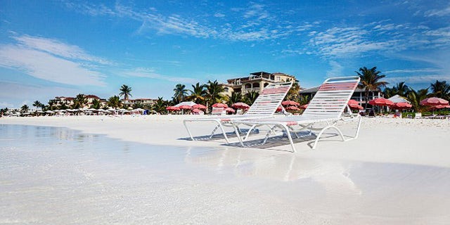 Beach chaises at water's edge on the soft white sands of Grace Bay Beach, Turks & Caicos