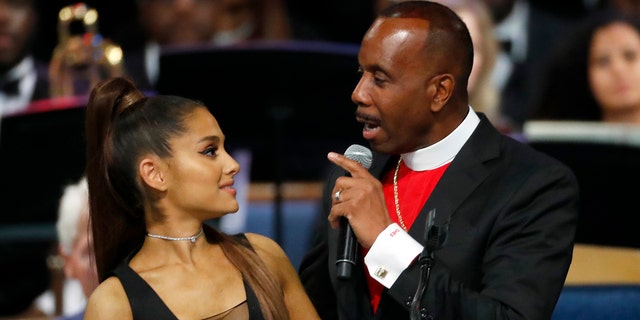 Bishop Charles H. Ellis, III, right, speaks with Ariana Grande after she performed during the funeral service for Aretha Franklin at Greater Grace Temple in Detroit, Aug. 31, 2018.