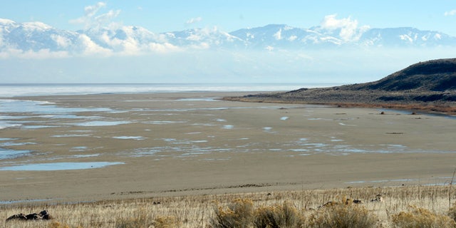 In this Wednesday Jan. 21, 2015, file photo, a view from the shore of Antelope Island looking east toward the Wasatch Mountains shows mudflats that are usually submerged by water of the Great Salt Lake in Utah.