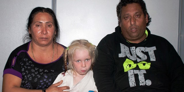 Oct. 17, 2013: In this police handout photo Christos Salis, 39, right, and his companion Eleftheria Dimopoulou, 40, or Selini Sali as the woman has two separate sets of identity papers, pose with the little girl only known as "Maria" in the Larisa regional police headquarters, Greece.