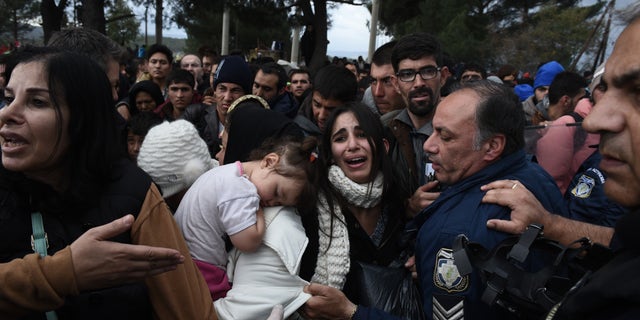 A woman cries as refugees scuffle with the Greek police in their effort to reach the borderline with Macedonia, near the Greek village of Idomeni, Sunday, Nov. 22, 2015. (AP)