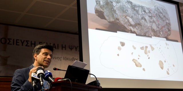 June 14, 2016: Greek archaeologist Christofilis Maggidis speaks as a photograph of a stone he believes belonged to the lost royal throne in the ancient palace of Mycenae, heart of the Mycenaean civilization, in southern Greece, during a press conference in Athens.