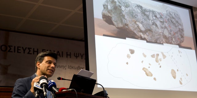 June 14, 2016: Greek archaeologist Christofilis Maggidis speaks as a photograph of a stone he believes belonged to the lost royal throne in the ancient palace of Mycenae, heart of the Mycenaean civilization, in southern Greece, during a press conference in Athens.