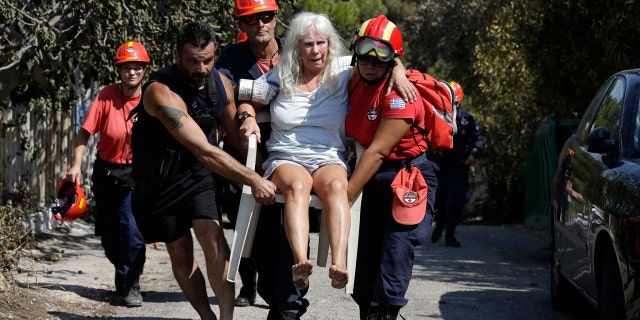 Members of a rescue team carry an injured woman in Mati, east of Athens.