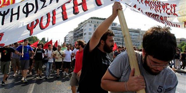 University students try to hold a banner during a protest in Athens, Thursday, Sept. 8, 2011.