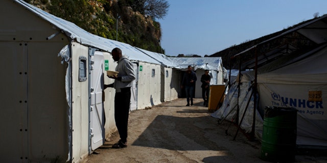Refugees and migrants make their way at the Souda municipality-run camp on the island of Chios, Greece, March 16, 2017.