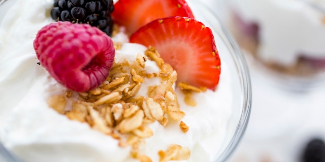 Breakfast parfait made from Greek yogurt and granola topped with fresh berries.