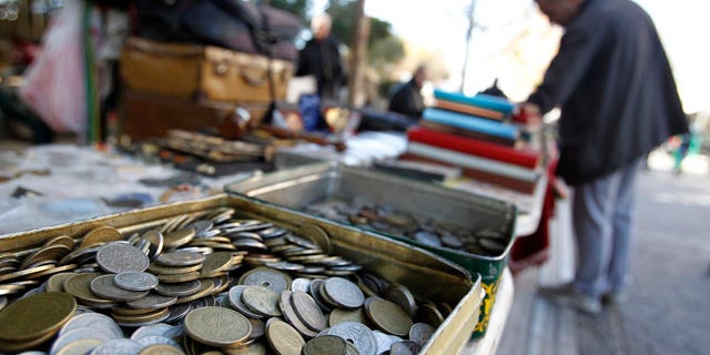 Dec. 9, 2011: Old drachma coins are displayed for sale at an outdoor market in Athens.