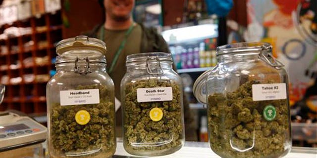 Jars of marijuana buds sit on the counter at the Denver Kush Club early Friday, Nov. 27, 2015, in north Denver. More than two dozen customers took advantage of a new Colorado holiday tradition of marijuana shops drawing customers with discounted weed and holiday gift sets. (AP Photo/David Zalubowski)