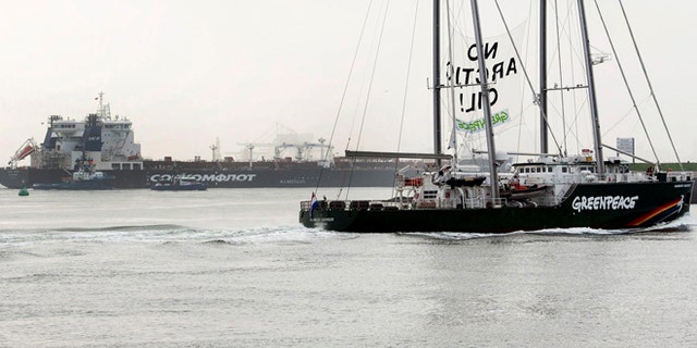 May 1, 2014: This image made available by environmental organization Greenpeace shows the Greenpeace ship Rainbow Warrior showing a banner reading: "No Arctic Oil" as Greenpeace activists aboard inflatable boats paint "No Arctic Oil" on the side of the Mikhail Ulyanov oil tanker, seen in the background, in Rotterdam, Netherlands.