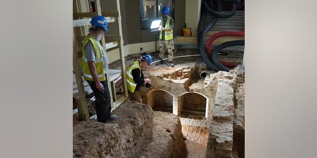 Archaeologists document the Tudor finds beneath the Painted Hall of the Old Royal Naval College shortly after their excavation. (Old Royal Naval College)