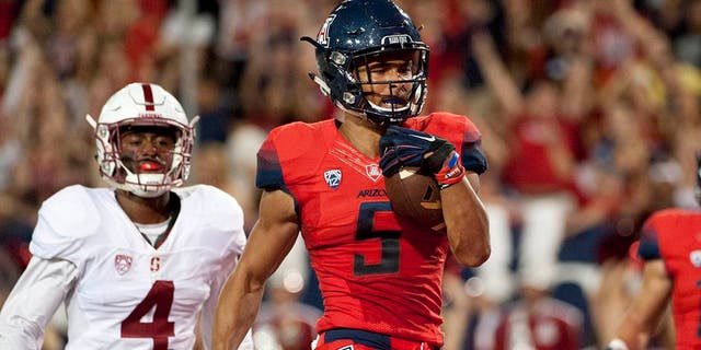 Oct 29, 2016; Tucson, AZ, USA; Arizona Wildcats wide receiver Trey Griffey (5) runs the ball for a touchdown under pressure from Stanford Cardinal cornerback Frank Buncom (4) during the second quarter at Arizona Stadium. Mandatory Credit: Casey Sapio-USA TODAY Sports