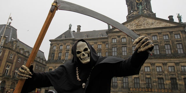 File photo - A street artist dressed as the grim reaper performs in front of the Dutch Royal Palace on Dam Square in Amsterdam March 19, 2013. (REUTERS/Yves Herman)