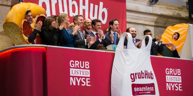 File photo: GrubHub CEO Matt Maloney (C) applauds after ringing the opening bell before the company's IPO on the floor of the New York Stock Exchange in New York April 4, 2014. (REUTERS/Lucas Jackson)