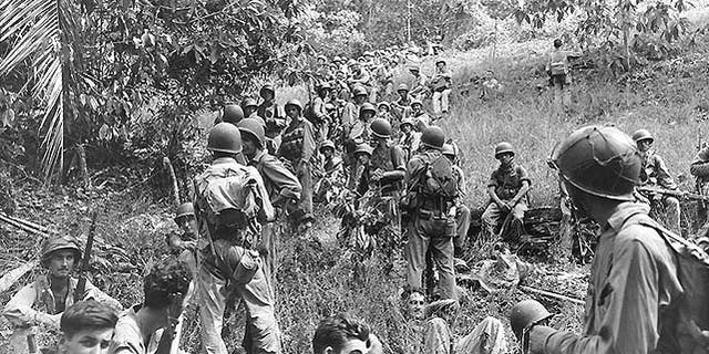 U.S. Marines rest in a field on Guadalcanal, circa August-December 1942. Most of these Marines are armed with M1903 bolt-action rifles and carry M1905 bayonets and USMC 1941 type packs. (U.S. Navy/National Archives)