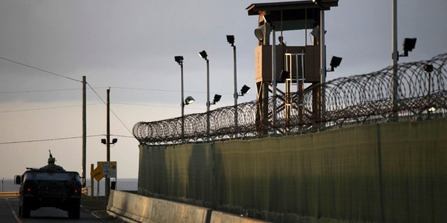 A U.S. trooper stands in the turret of a vehicle with a machine gun, left, as a guard looks out from a tower at the detention facility of Guantanamo Bay U.S. Naval Base in Cuba.