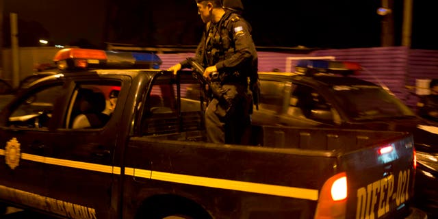 Agentes policiales patrullan cerca de la escena de un crimen en el barrio Guajitos, en las afueras de la ciudad de Guatemala, la madrugada del jueves 1 de octubre de 2015. Tres pandilleros murieron y al menos seis fueron detenidos durante un ataque simultáneo contra una estación policial y policÃas que realizaban patrullajes, de acuerdo con Elmer Sosa, viceministro de gobernación. (AP Foto/Moises Castillo)