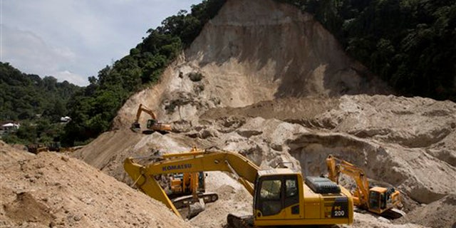 Oct. 9, 2015: Bulldozers sit at the site of a mudslide in Cambray, a neighborhood in the suburb of Santa Catarina Pinula, on the outskirts of Guatemala City.