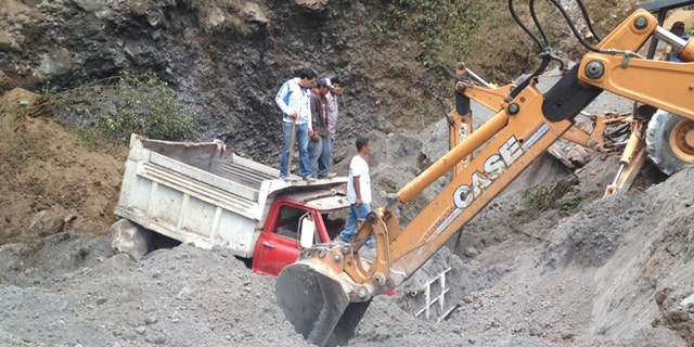 Nov. 7, 2012: Residents use heavy equipment to look for people feared buried at a sand mine, after a magnitude 7.4 earthquake struck in San Marcos, Guatemala.