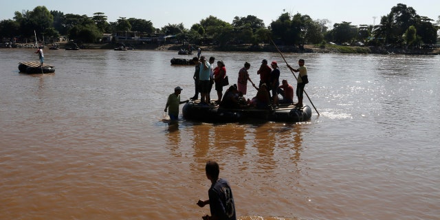People arrive on a raft after crossing the Suchiate river, a natural border between Mexico and Guatemala.