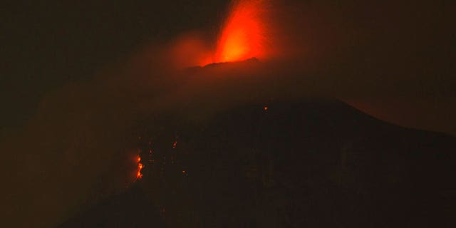 In this image taken with a long exposure, the Volcan de Fuego, or Volcano of Fire, spews molten rock from its crater in Alotenango, Guatemala, Sunday, June 3, 2018. Rescuers struggled to reach rural residents cut off by the deadly volcanic eruption Sunday. (AP Photo/Luis Soto)
