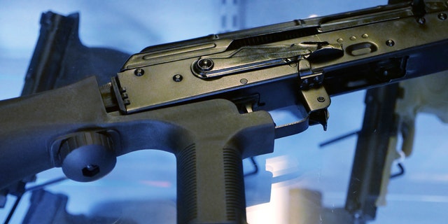 A bump stock is attached to a semi-automatic rifle at the Gun Vault store and shooting range in South Jordan, Utah. 