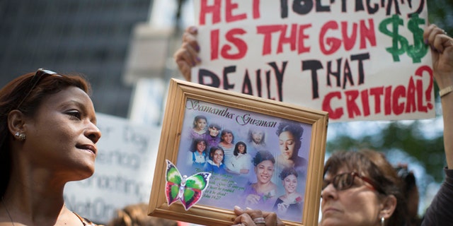 FILE: June 14, 2014: Diana Rodriguez with a picture of her daughter, a victim of gun violence, at a rally outside city hall in New York City.