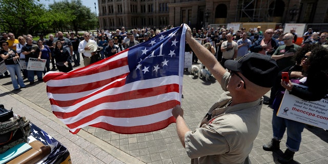 A man holding a 3% flag as a group recited the pledge during a pro gun-rights rally at the state capitol in Austin, Texas.