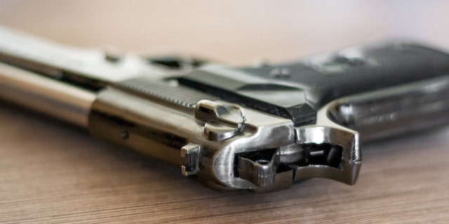 handgun on the wooden surface, closeup, useful for various security,protection or criminal topics