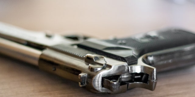 handgun on the wooden surface, closeup, useful for various security,protection or criminal topics