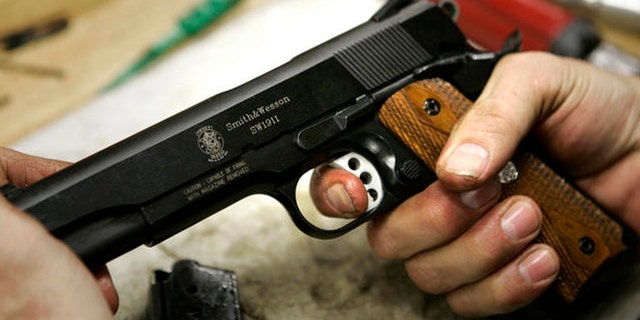 FILE: Undated: A model 1911 pistol is held in the hands of an assembler at the Smith & Wesson factory in Springfield, Mass.