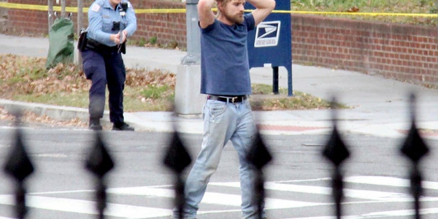 Edgar Maddison Welch, 28 of Salisbury, N.C., surrenders to police Sunday, Dec. 4, 2016, in Washington. Welch, who said he was investigating a conspiracy theory about Hillary Clinton running a child sex ring out of a pizza place, fired an assault rifle inside the restaurant on Sunday injuring no one, police and news reports said. (Sathi Soma via AP)