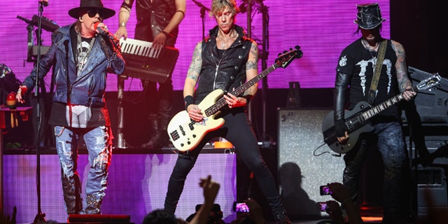 April 23, 2014 file photo, Axl Rose, from left, Duff McKagan and DJ Ashba of Guns N' Roses perform in Los Angeles.