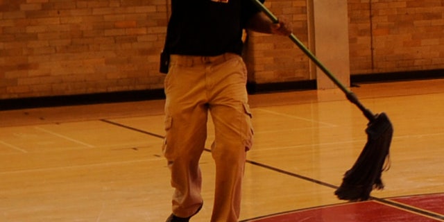 Lafayette Rockette, facility manager at East High School, cleans the floor, Monday, November 06, 2011, in the Calloway Gym at East High School that was built in 1924. RJ Sangosti, The Denver Post