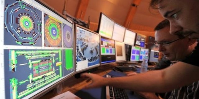 European Center for Nuclear Research (CERN) scientists control computer screens showing traces on Atlas experiment of the first protons injected in the Large Hadron Collider (LHC) during its switch on operation in CERN's control room, near Geneva, Switzerland.