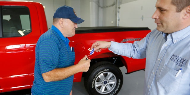 In this Thursday, Nov. 19, 2015, photo, Alton John, left, from Kittanning, Pa., gets the keys to his new 2015 Ford F-150 Supercab 4x4 pickup truck from salesman Robert Myers as he takes delivery at Butler County Ford in Butler, Pa. Haggling over a car price isnt for everyone. The angst has spawned a small but growing trend toward no-haggle alternatives found at discount club stores, some dealers and on several Internet sites. (AP Photo/Keith Srakocic)