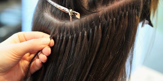 MUNICH, GERMANY - JANUARY 10: A hair stylist fixes extensions to the hair of Model Marie Nasemann during a hair dressing session where Nasemann gets hair extensions on January 10, 2014 in Munich, Germany. (Photo by Lennart Preiss/Getty Images)