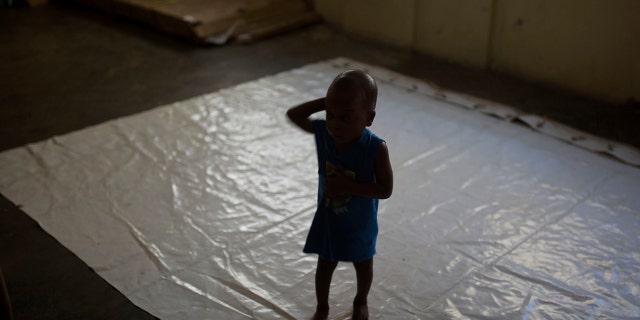 A boy stands on a tarp at the Foyer Notre Dame de la Nativite orphanage on the outskirts of Port-au-Prince, Haiti, Friday, Feb. 2, 2018.