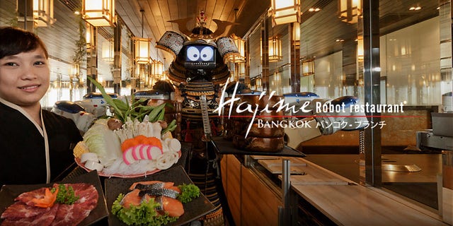 Hajime Robot Restaurant in Bangkok employs robots as their waitstaff. Diners sit facing a glass enclosure where the robots move back and forth on a track and serve customers through windows.