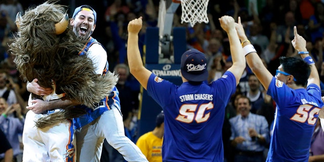 Nov. 18, 2013: Cameron Rodriguez, second from left, celebrates with Thunder mascot Rumble, left, after hitting a half court shot to win $20,000 during a time out of an NBA basketball game between the Oklahoma City Thunder and the Denver Nuggets in Oklahoma City. (AP/Sue Ogrocki)