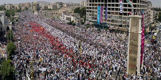 A citizen journalism image made July 22 on a mobile phone and provided by Shaam News Network shows Syrian anti-regime protesters gather during a rally in al-Assy square in the western city of Hama, Syria.