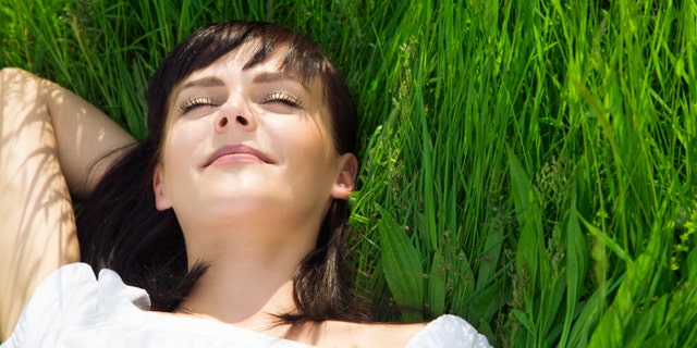 beautiful girl lying down of grass. Copy space