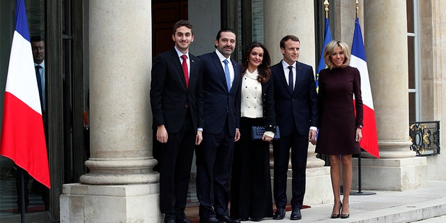 French President Emmanuel Macron and his wife Brigitte, right, greet Lebanon's Prime Minister Saad Hariri, second left, his wife Lara, center left, and their son Hussam upon their arrival at the Elysee Palace in Paris, Saturday.