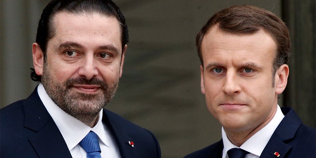 French President Emmanuel Macron, right, poses for photographers with Lebanon's Prime Minister Saad Hariri prior to their meeting at the Elysee Palace in Paris, Saturday