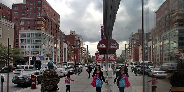 This Oct. 6, 2010 photo shows a new red brick hi-rise, left, an ongoing construction project which will house the new Aloft Hotel and condominiums in Harlem, is reflected in the windows of the Magic Johnson theater building in New York.